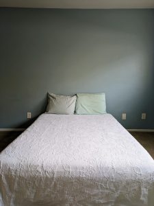 a bed in front of an empty wall