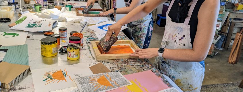 two people screenprinting