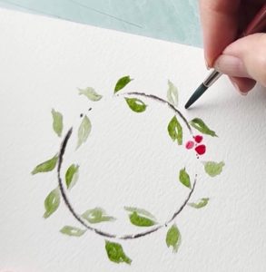 watercoloring a small wreath on watercolor paper